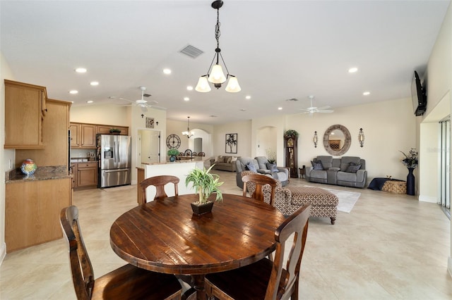 dining area featuring light tile patterned flooring, lofted ceiling, and ceiling fan with notable chandelier