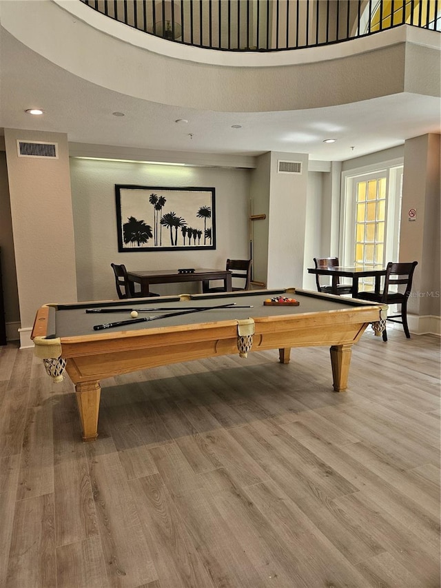 playroom featuring pool table, a towering ceiling, and light wood-type flooring