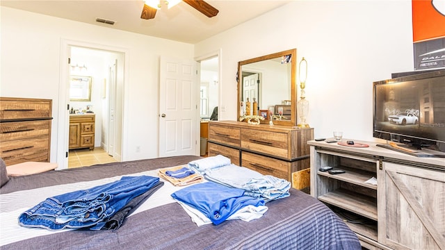 tiled bedroom featuring connected bathroom and ceiling fan