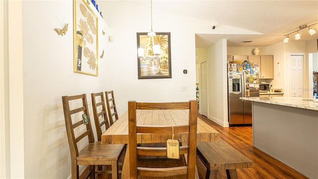 dining space with dark wood-type flooring and vaulted ceiling