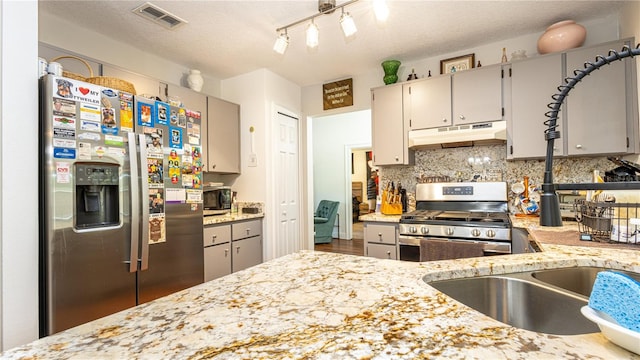 kitchen featuring appliances with stainless steel finishes, a textured ceiling, and gray cabinets