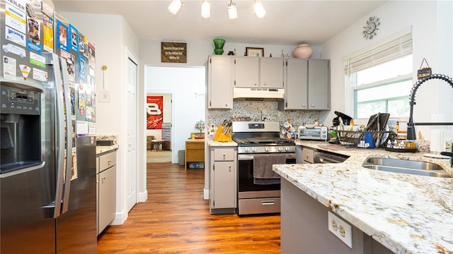 kitchen featuring backsplash, appliances with stainless steel finishes, gray cabinetry, light hardwood / wood-style floors, and sink