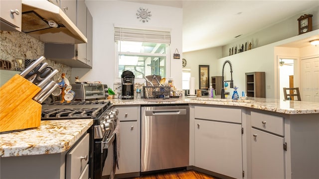 kitchen featuring kitchen peninsula, dark hardwood / wood-style flooring, appliances with stainless steel finishes, gray cabinets, and sink