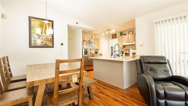 kitchen featuring dark hardwood / wood-style floors, backsplash, light stone countertops, stainless steel fridge with ice dispenser, and decorative light fixtures