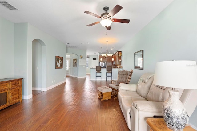 living room with dark hardwood / wood-style floors and ceiling fan with notable chandelier