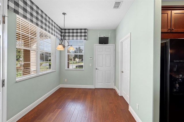 interior space featuring dark hardwood / wood-style floors and an inviting chandelier