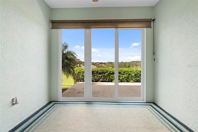 doorway with carpet floors and plenty of natural light