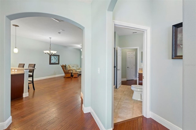 hall featuring a notable chandelier and hardwood / wood-style flooring