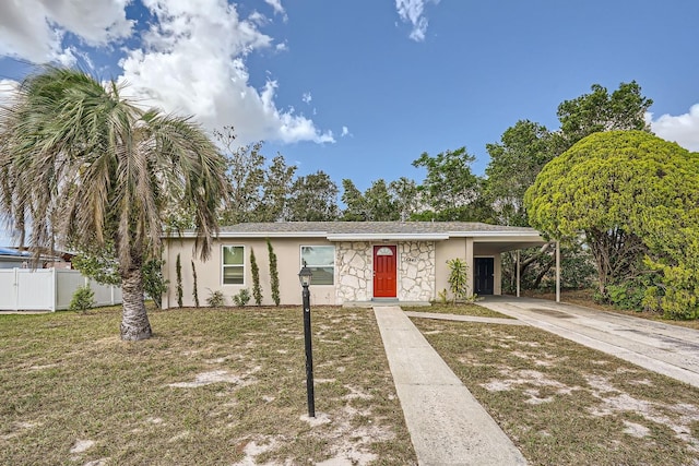 ranch-style home featuring a front lawn and a carport