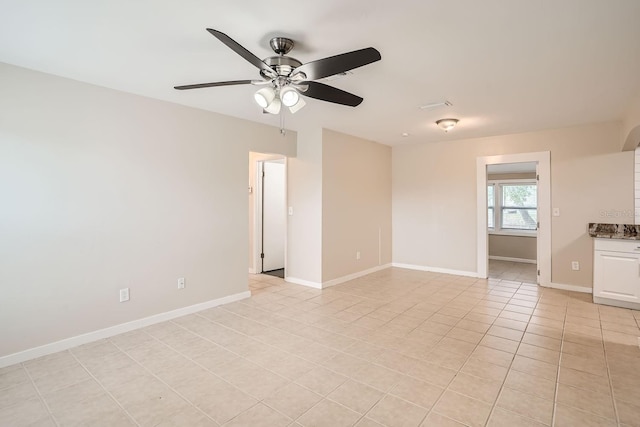 empty room with light tile patterned floors and ceiling fan