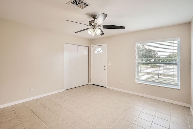 tiled empty room with ceiling fan