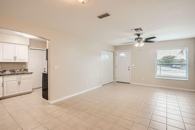 unfurnished living room featuring light tile patterned floors and ceiling fan