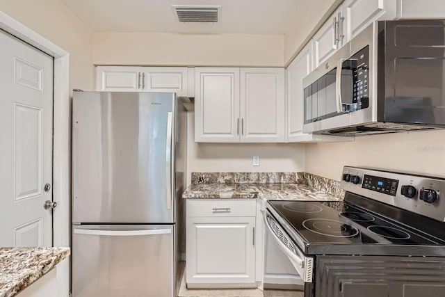 6445 Skyline Ct, Spring Hill, FL 34606 - kitchen with appliances with stainless steel finishes, white cabinets, and light stone countertops