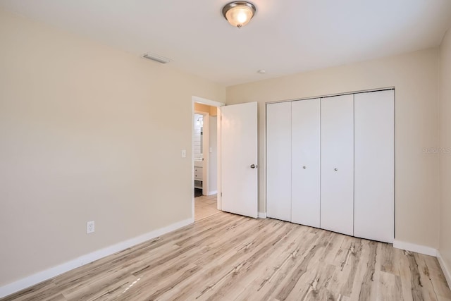 unfurnished bedroom with light wood-type flooring and a closet