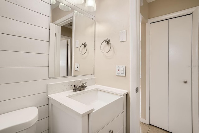 bathroom with toilet, vanity, and tile patterned floors