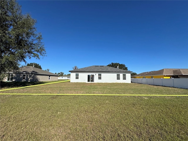 rear view of property with a lawn