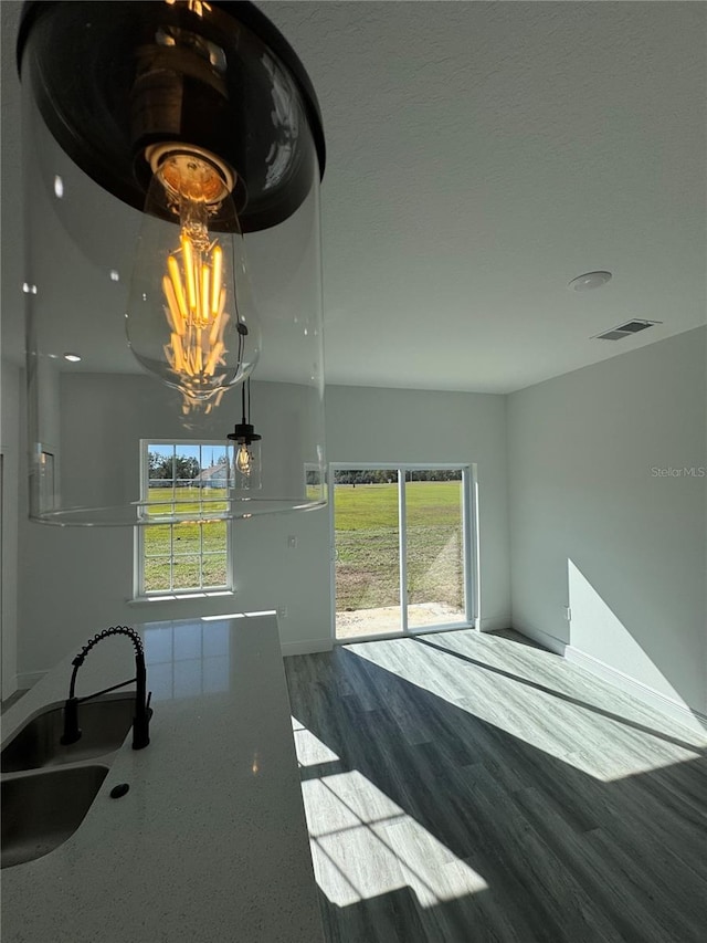 interior space featuring sink, wood-type flooring, and a textured ceiling