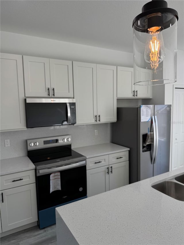 kitchen featuring white cabinetry, appliances with stainless steel finishes, sink, and light wood-type flooring