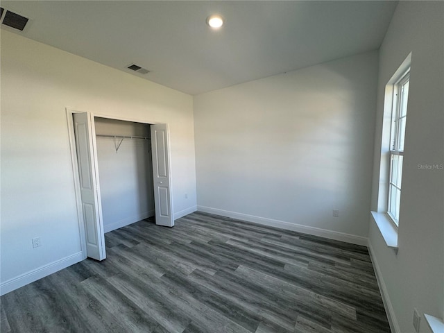 unfurnished bedroom featuring a closet and dark hardwood / wood-style floors