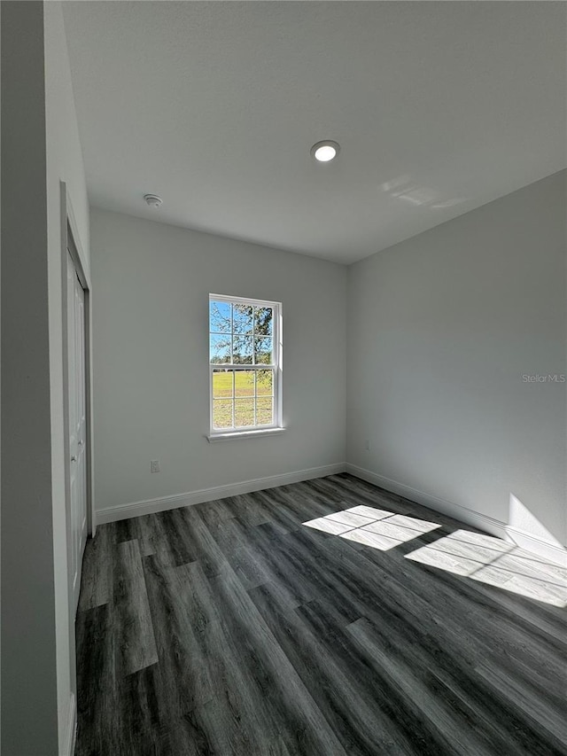 unfurnished bedroom with dark hardwood / wood-style flooring and a closet