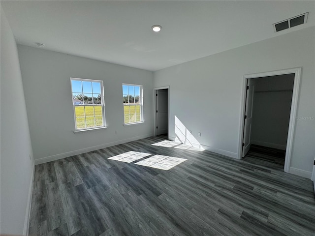 unfurnished bedroom featuring dark hardwood / wood-style flooring and a spacious closet