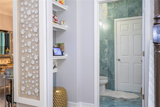 bathroom with crown molding and toilet