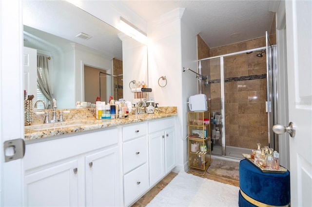 bathroom with vanity, a textured ceiling, tile patterned flooring, and a shower with door