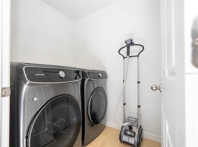 washroom with light tile patterned flooring and washer and dryer