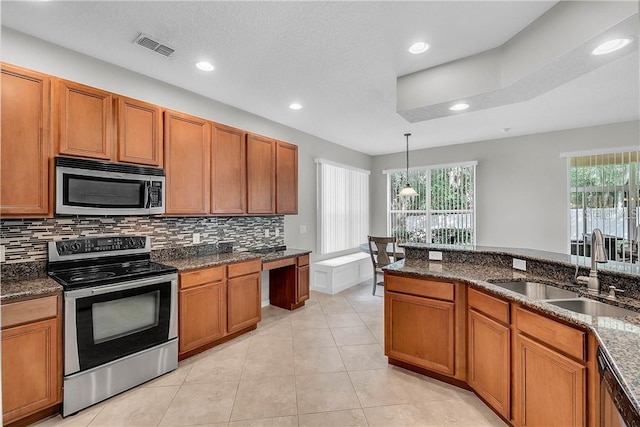 kitchen with visible vents, decorative backsplash, appliances with stainless steel finishes, a sink, and light tile patterned flooring