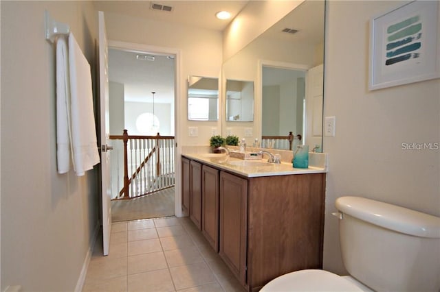 bathroom featuring double vanity, visible vents, toilet, a sink, and tile patterned floors