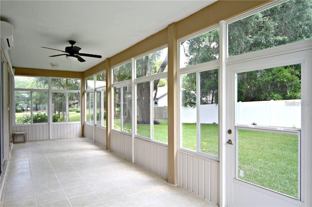 unfurnished sunroom with a wall mounted AC and a ceiling fan