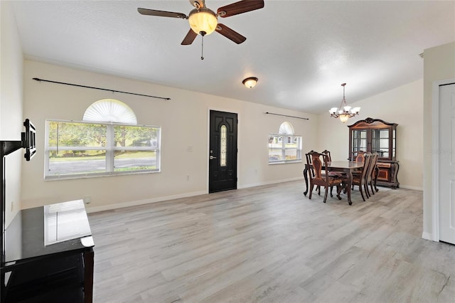 dining area featuring baseboards, light wood-style flooring, and ceiling fan with notable chandelier