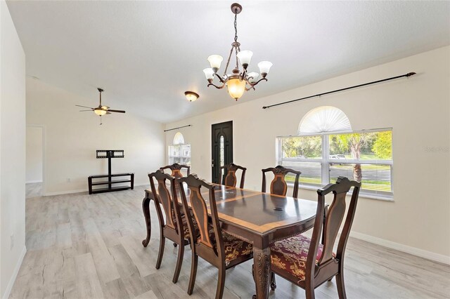dining space with baseboards, light wood-style flooring, and ceiling fan with notable chandelier