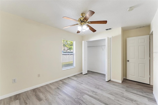 unfurnished bedroom with a closet, ceiling fan, a textured ceiling, and light hardwood / wood-style floors