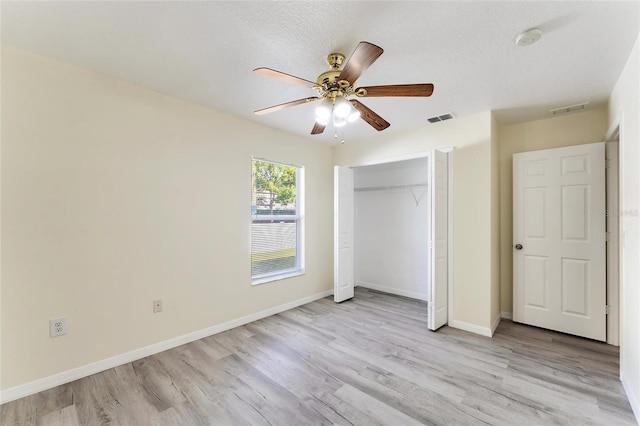 unfurnished bedroom featuring a closet, light wood-style flooring, and visible vents