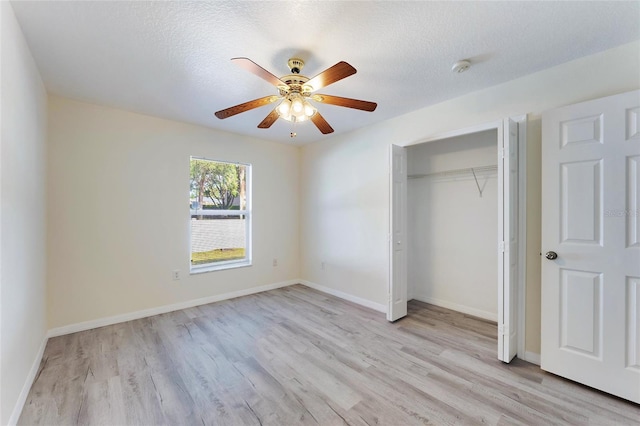 unfurnished bedroom featuring a closet, ceiling fan, a textured ceiling, and light hardwood / wood-style floors