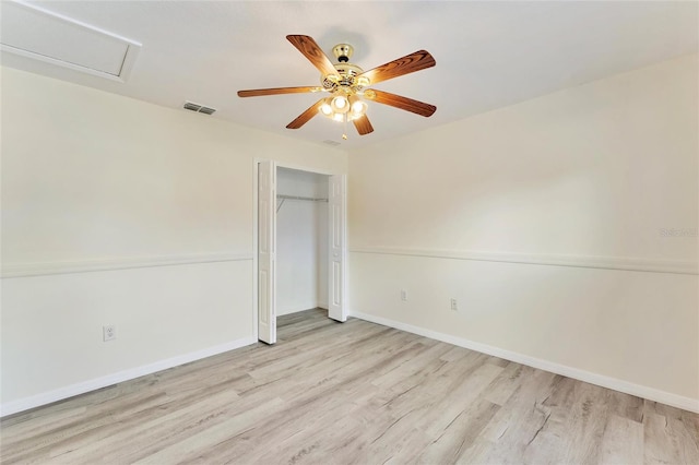 unfurnished bedroom featuring light wood-style floors, baseboards, a closet, and visible vents