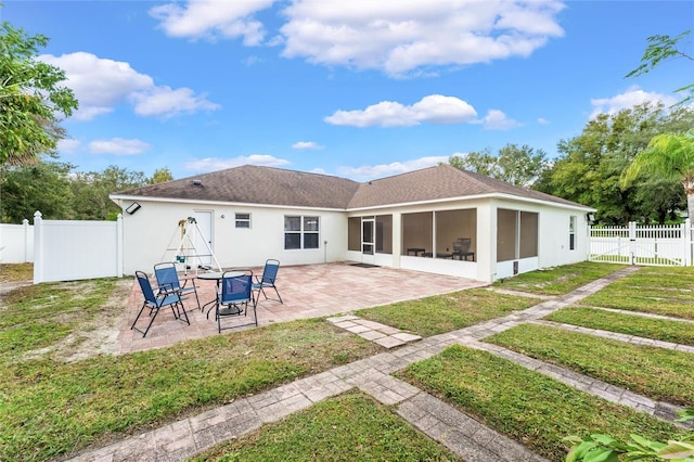 back of house featuring a patio area, a lawn, and a sunroom