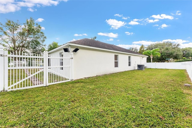 view of home's exterior with a lawn and central AC unit