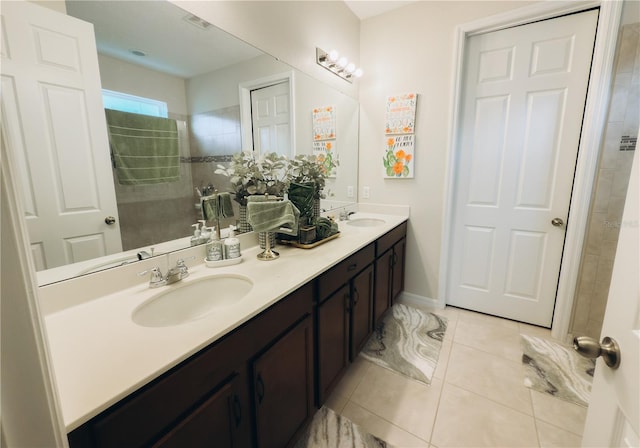 bathroom with vanity, tiled shower, and tile patterned flooring