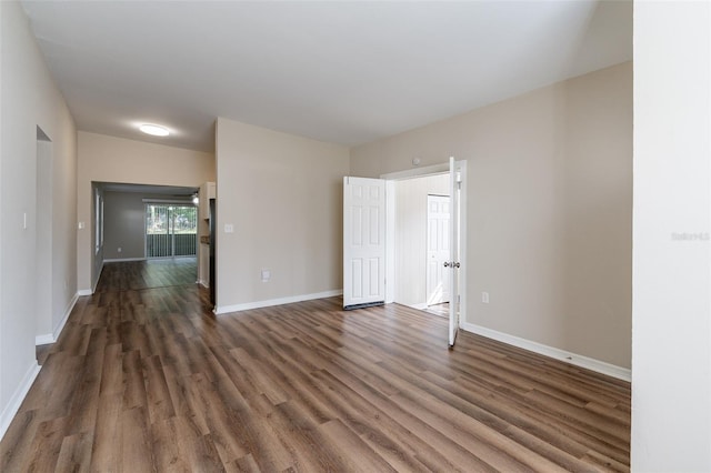 unfurnished room with dark hardwood / wood-style flooring