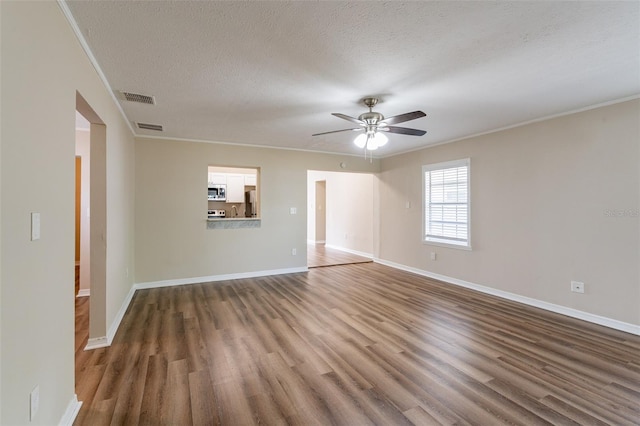 empty room featuring dark wood-type flooring, ceiling fan, and a textured ceiling