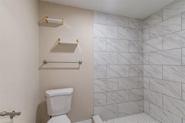 bathroom featuring toilet and a tile shower