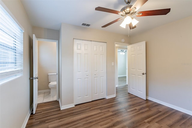 unfurnished bedroom featuring ceiling fan, dark hardwood / wood-style floors, and a closet