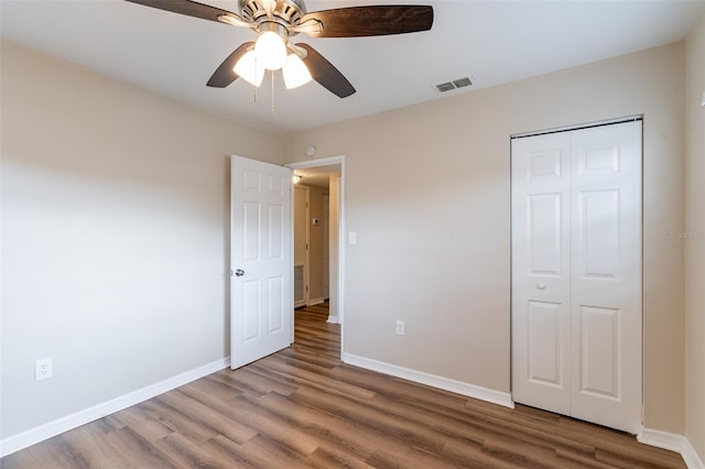 unfurnished bedroom with a closet, hardwood / wood-style floors, and ceiling fan