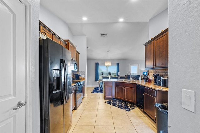 kitchen with kitchen peninsula, hanging light fixtures, light tile patterned flooring, black appliances, and light stone counters