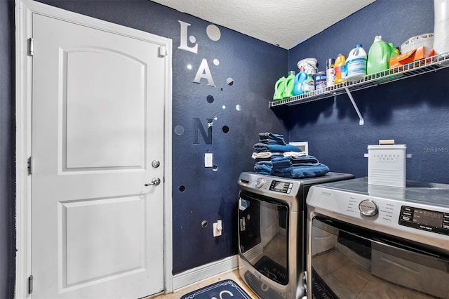 laundry room with washer and dryer and a textured ceiling