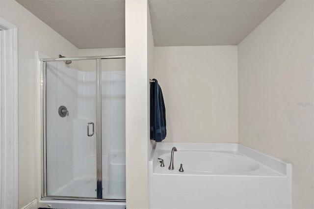 bathroom featuring separate shower and tub and a textured ceiling