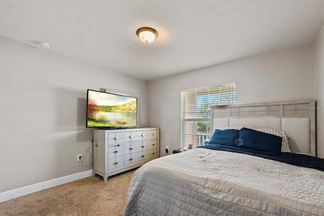 bedroom featuring a textured ceiling and light colored carpet