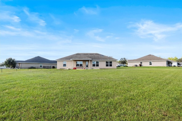 rear view of house featuring a lawn